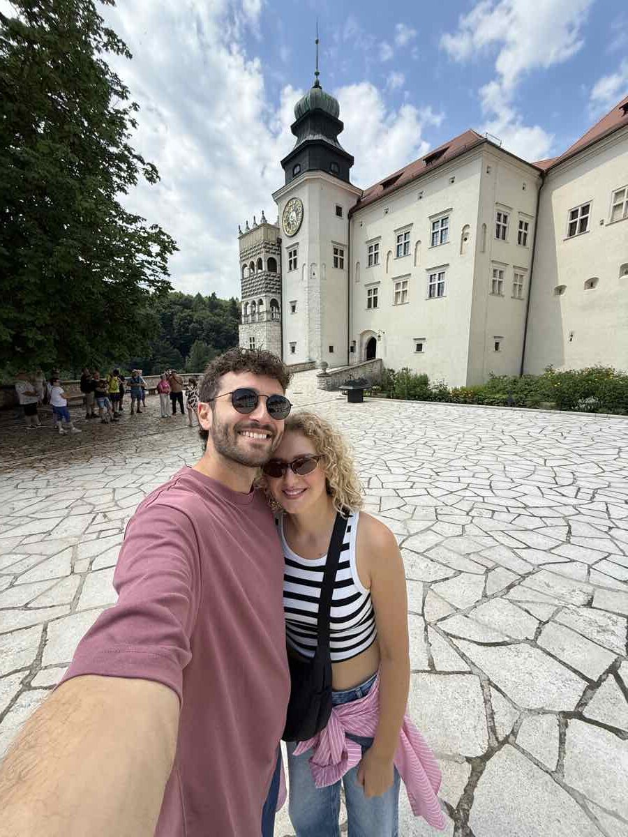 Turisti davanti alla torre dell'orologio del castello di Pieskowa Skala