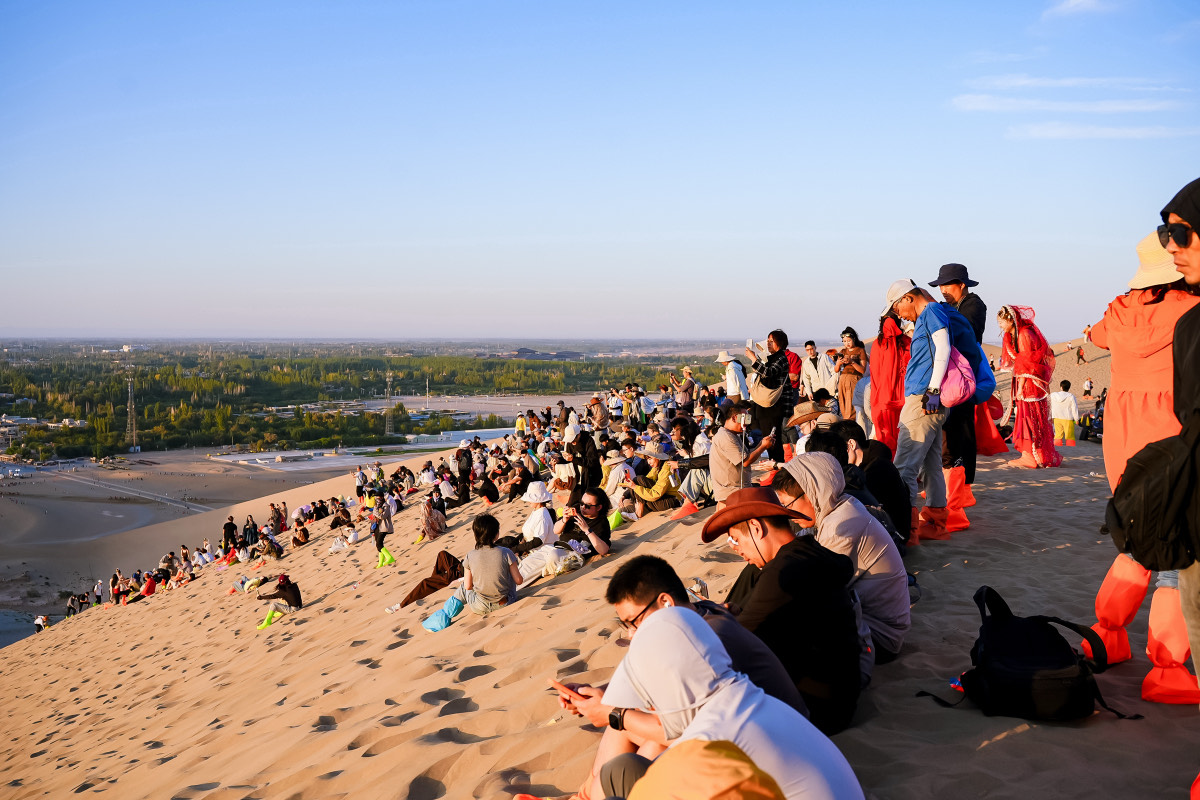 Folla sulle dune di Mingsha in attesa del tramonto