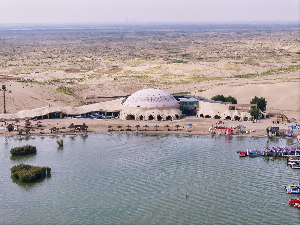 Il centro visitatori del lago Shahu visto dall'alto, tra l'acqua e le dune