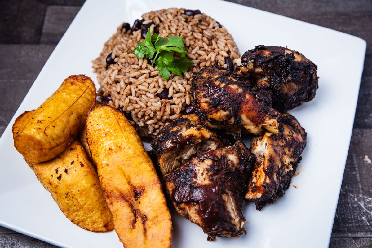 Piatto di jerk chicken con riso, fagioli e platano fritto