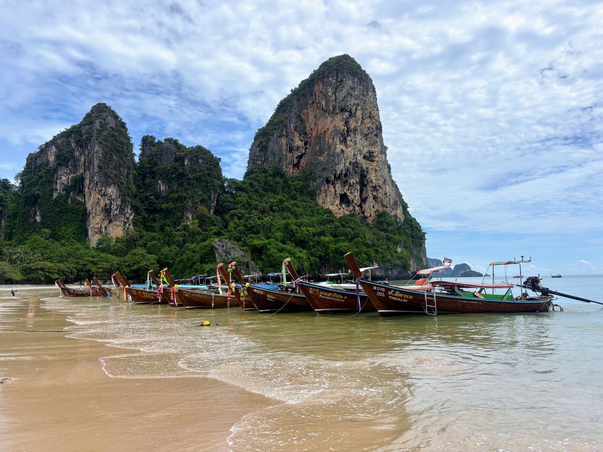 Cosa vedere in Thailandia fuori dai soliti giri: Isan, Krabi e Chiang Rai 2 Barche longtail sulla spiaggia di Railay, Krabi, con le falesie calcaree